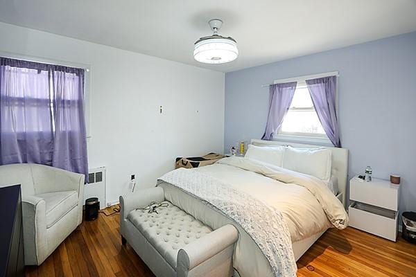 bedroom featuring radiator heating unit and wood finished floors