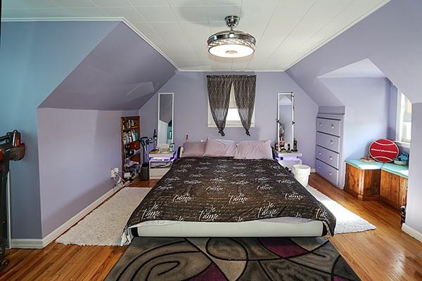 bedroom featuring vaulted ceiling, wood finished floors, and baseboards