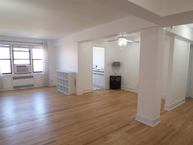 empty room with radiator, wood finished floors, baseboards, and cooling unit