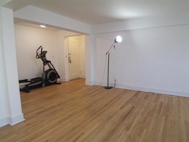 exercise area with light wood-style flooring and baseboards