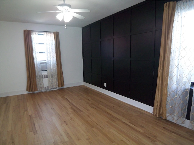 unfurnished room featuring baseboards, light wood finished floors, and ceiling fan