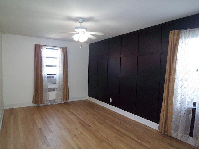 spare room featuring baseboards, light wood-style floors, and ceiling fan