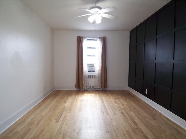 empty room featuring baseboards, a ceiling fan, and light wood-style floors