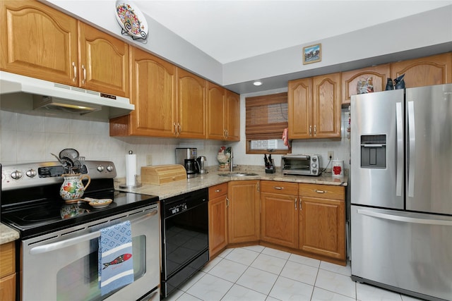 kitchen featuring a toaster, brown cabinetry, appliances with stainless steel finishes, light stone counters, and under cabinet range hood