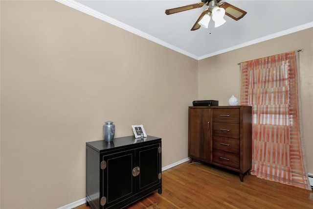 interior space with ceiling fan, ornamental molding, wood finished floors, and baseboards