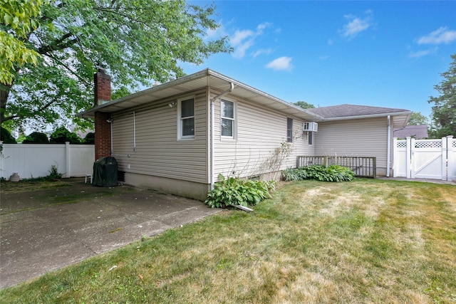 exterior space featuring a yard, a chimney, a patio, a gate, and fence