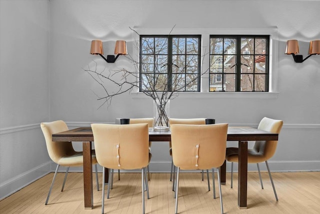 dining space with baseboards and wood finished floors