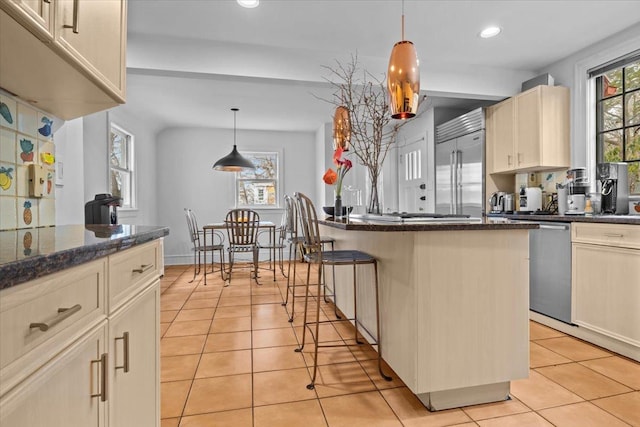 kitchen featuring recessed lighting, a center island, stainless steel appliances, and light tile patterned flooring