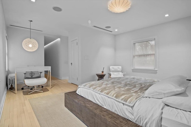 bedroom with radiator heating unit, visible vents, hardwood / wood-style floors, and recessed lighting