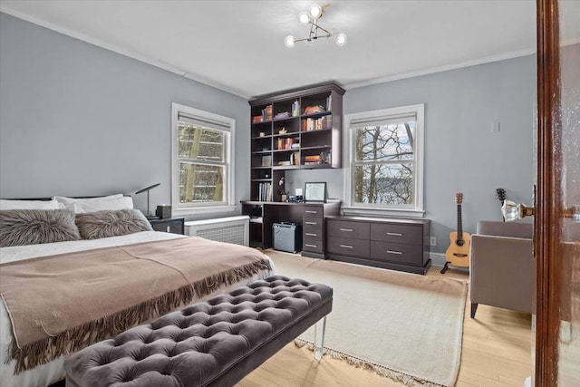 bedroom with crown molding, multiple windows, light wood-style flooring, and radiator
