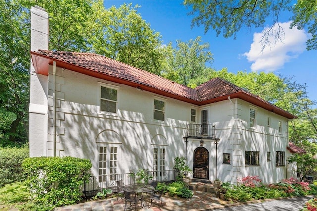 2737 Palisade Ave, Bronx, NY 10463 - view of front of property featuring a tiled roof, a chimney, stucco siding, and a patio