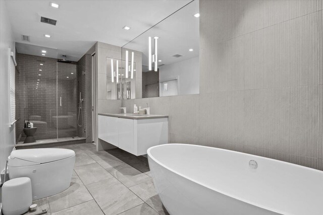 2737 Palisade Ave, Bronx, NY 10463 - full bath featuring vanity, a shower stall, a freestanding bath, tile walls, and toilet