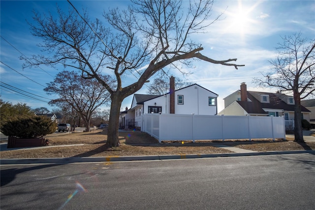 view of property exterior with a residential view and fence