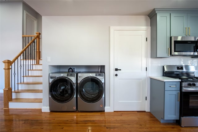 clothes washing area featuring washing machine and dryer, laundry area, and dark wood-style flooring