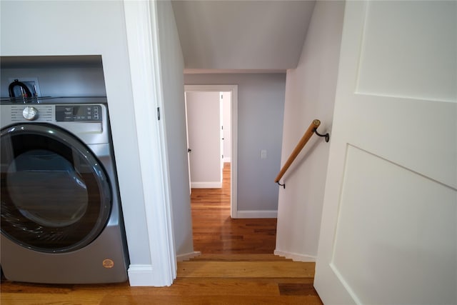 laundry room with laundry area, wood finished floors, washer / dryer, and baseboards