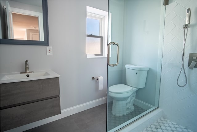 bathroom with toilet, vanity, baseboards, a shower stall, and tile patterned floors