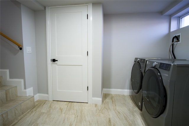 laundry room with baseboards and separate washer and dryer