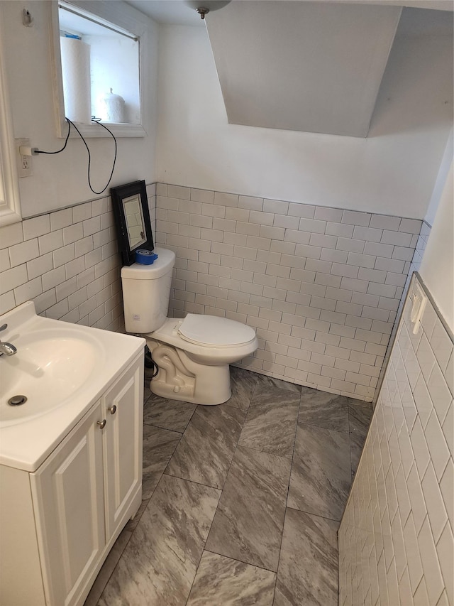 bathroom with wainscoting, tile walls, and vanity