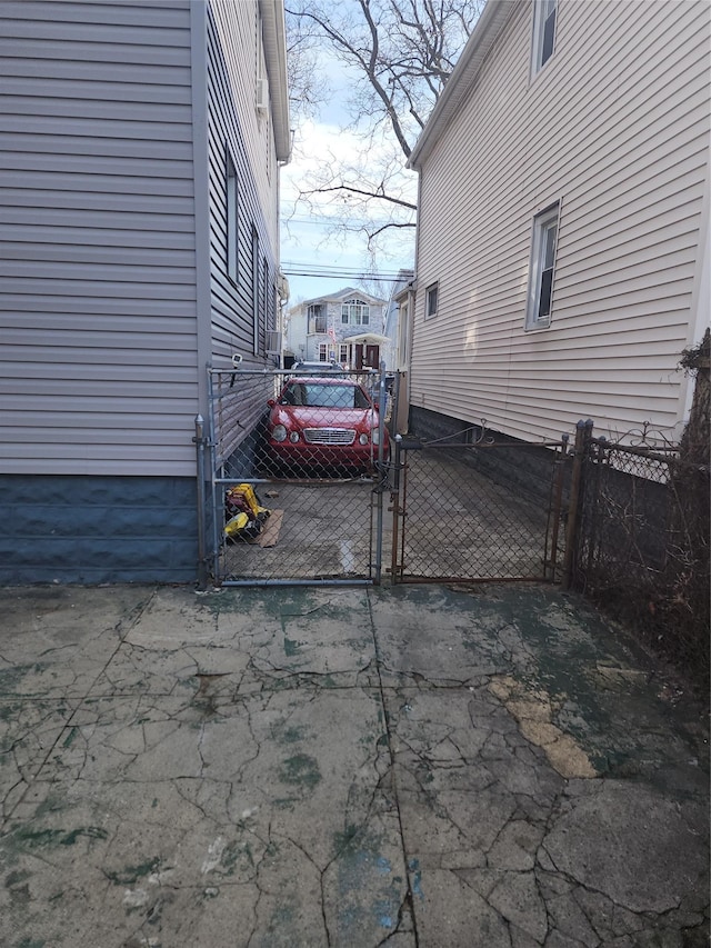 view of vehicle parking featuring fence and a gate