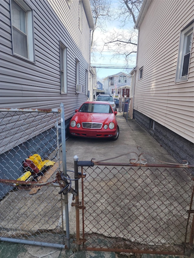 view of car parking featuring a residential view, cooling unit, a gate, and fence