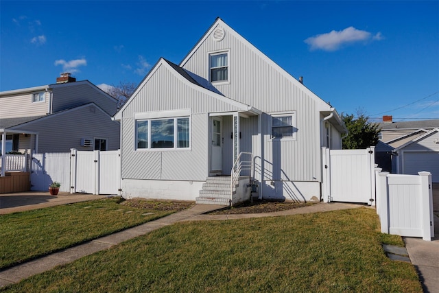 view of front of house featuring a gate, fence, board and batten siding, and a front yard