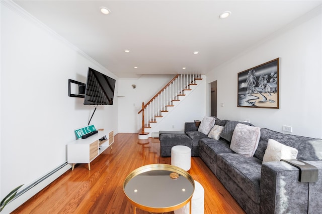 living room featuring a baseboard heating unit, stairway, wood finished floors, and crown molding