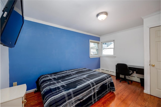 bedroom with baseboards, a baseboard radiator, ornamental molding, and wood finished floors