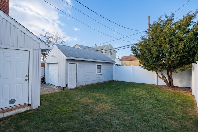 view of yard featuring a garage, an outbuilding, and a fenced backyard