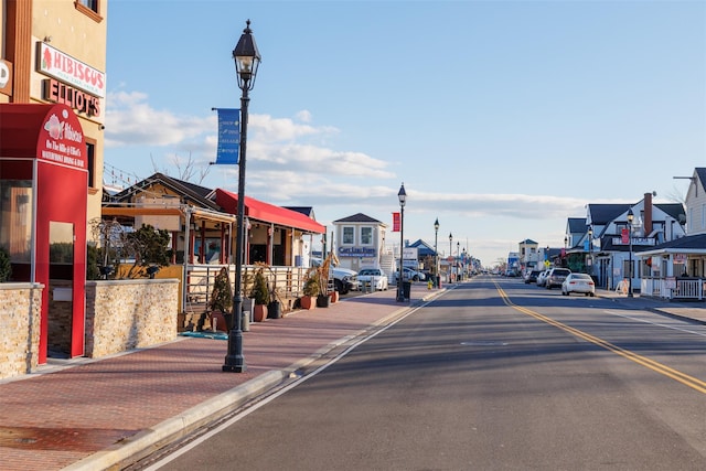 view of street featuring curbs, sidewalks, and street lights