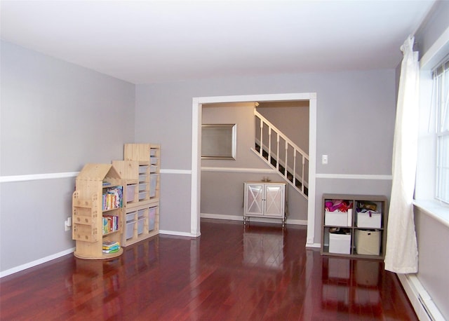 rec room featuring dark wood-type flooring, a baseboard radiator, and baseboards