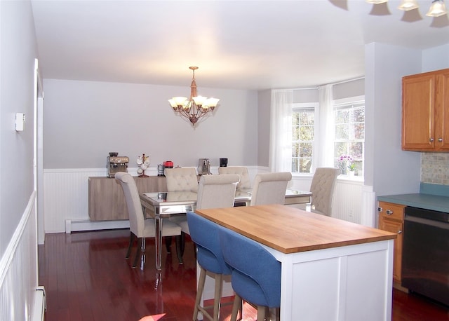 dining space featuring a wainscoted wall, a baseboard radiator, dark wood-style floors, and a notable chandelier