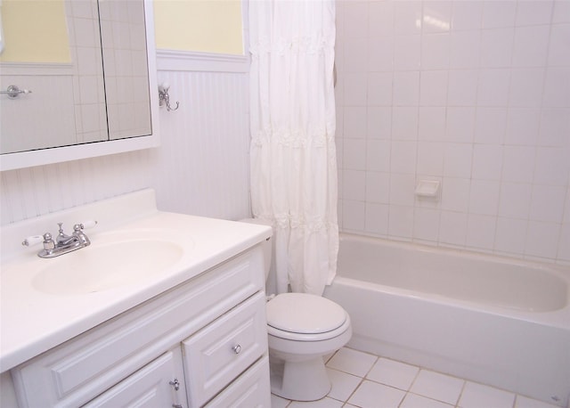 full bathroom featuring wainscoting, toilet, tile patterned flooring, shower / bath combination with curtain, and vanity