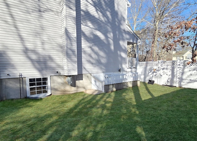 view of side of property featuring fence and a lawn