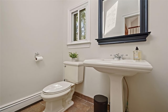 bathroom with a sink, baseboards, a baseboard radiator, and toilet