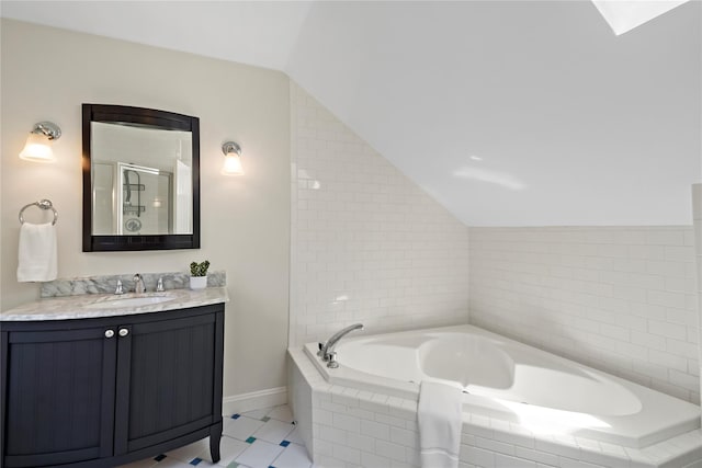 bathroom featuring tile patterned flooring, vanity, a shower stall, vaulted ceiling, and a garden tub
