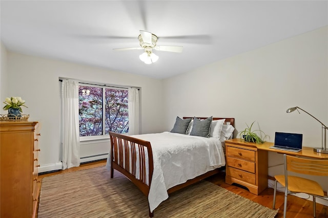 bedroom featuring a baseboard radiator, ceiling fan, and wood finished floors