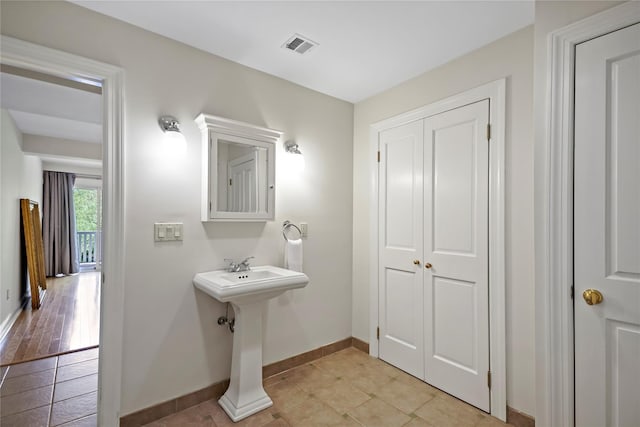 bathroom featuring a sink, baseboards, visible vents, and tile patterned floors