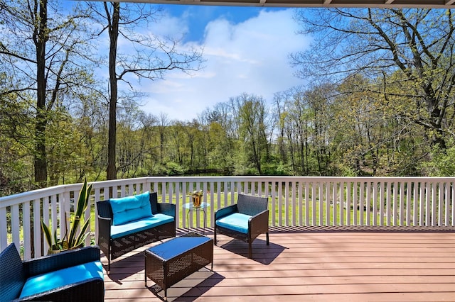 wooden terrace with outdoor lounge area and a wooded view