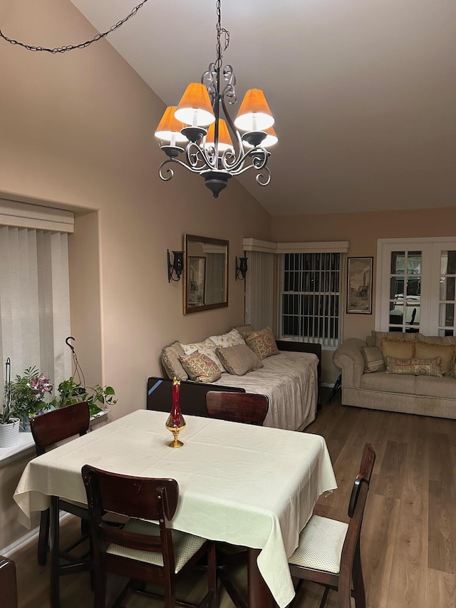 dining room with lofted ceiling, a chandelier, and wood finished floors