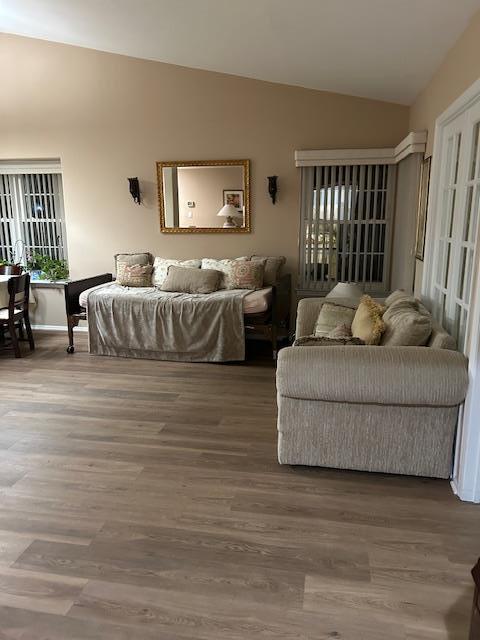 living area featuring lofted ceiling and wood finished floors