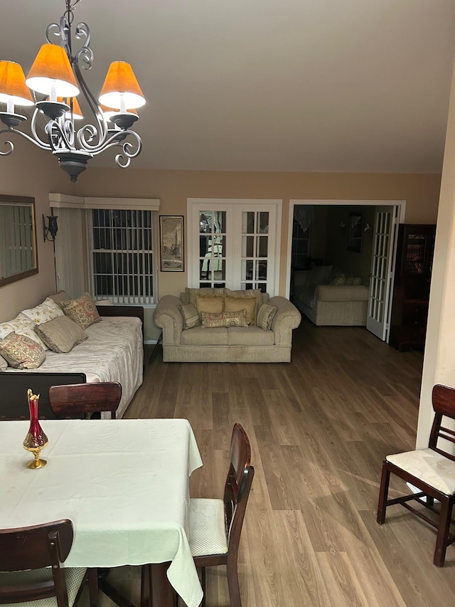 living room featuring french doors, wood finished floors, and a notable chandelier