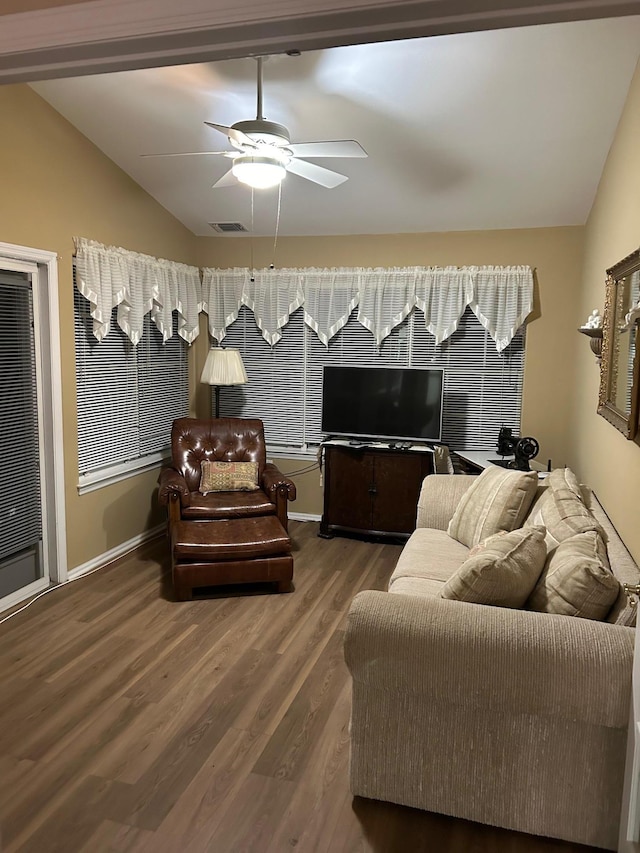 living room with lofted ceiling, ceiling fan, visible vents, and wood finished floors