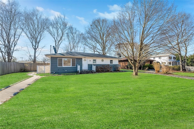 ranch-style house featuring fence and a front lawn