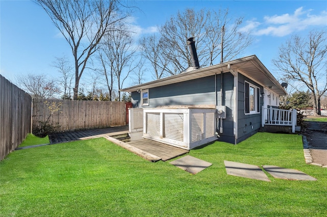 rear view of property with a lawn and a fenced backyard