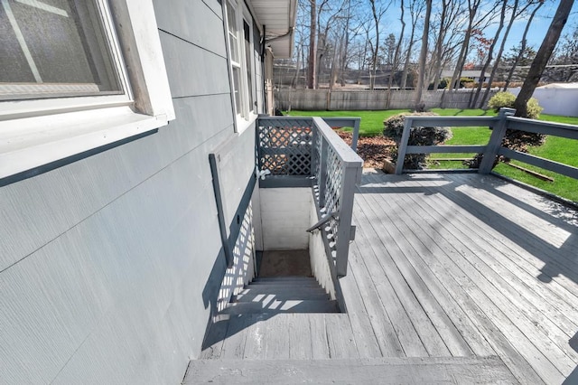 wooden terrace featuring a yard and fence