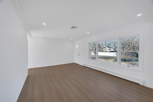 empty room with ornamental molding, a baseboard radiator, wood finished floors, and visible vents