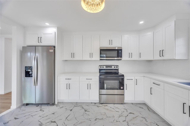 kitchen with light countertops, appliances with stainless steel finishes, and white cabinetry