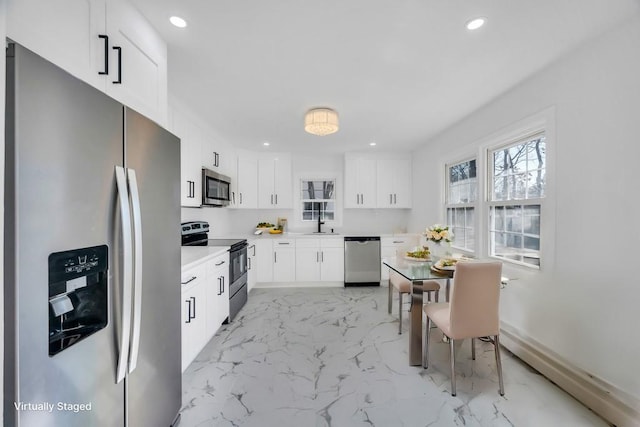 kitchen featuring marble finish floor, recessed lighting, light countertops, appliances with stainless steel finishes, and white cabinetry