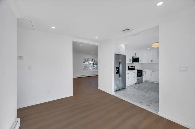 interior space with stainless steel appliances, wood finished floors, visible vents, white cabinets, and baseboard heating