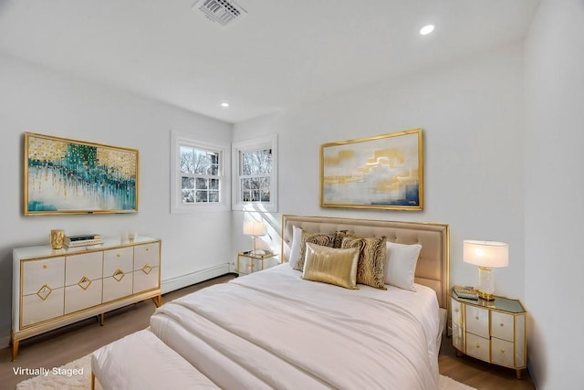 bedroom featuring visible vents, baseboard heating, wood finished floors, and recessed lighting